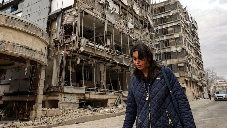 A woman walks on the street following an Israeli and U.S. strike on Gandhi Hotel Hospital, in Tehran