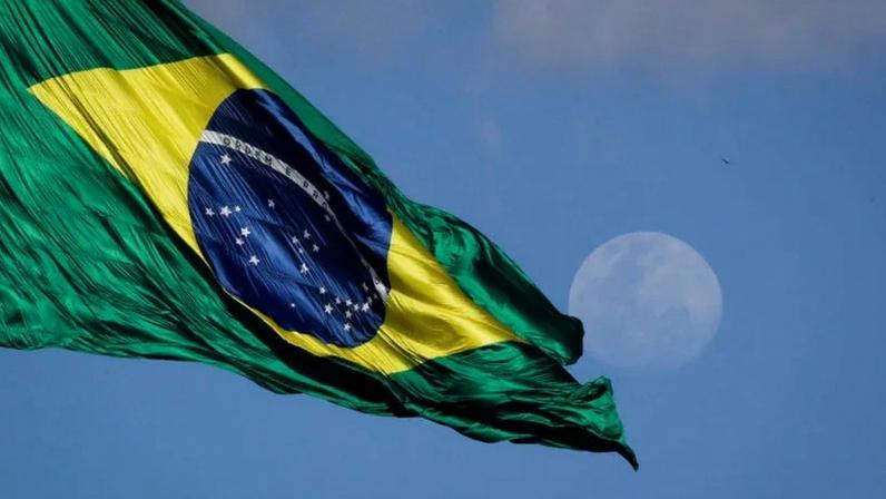 Quando a dívida sobe, uma parte cada vez maior do Orçamento passa a ser destinada ao pagamento de juros e à rolagem da dívida. Esse cenário reduz a capacidade do Estado de investir em infraestrutura, educação ou políticas públicas que aumentam produtividade; na imagem, a bandeira do Brasil hasteada no mastro da Praça dos Três Poderes, em Brasília