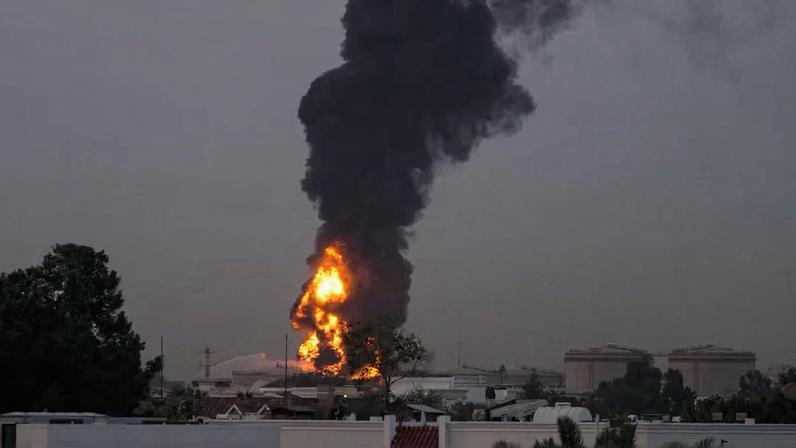 Fire and plumes of smoke rise after a drone struck a fuel tank near Dubai International Airport on 16 March, 2026, forcing the temporary suspension of flights.
