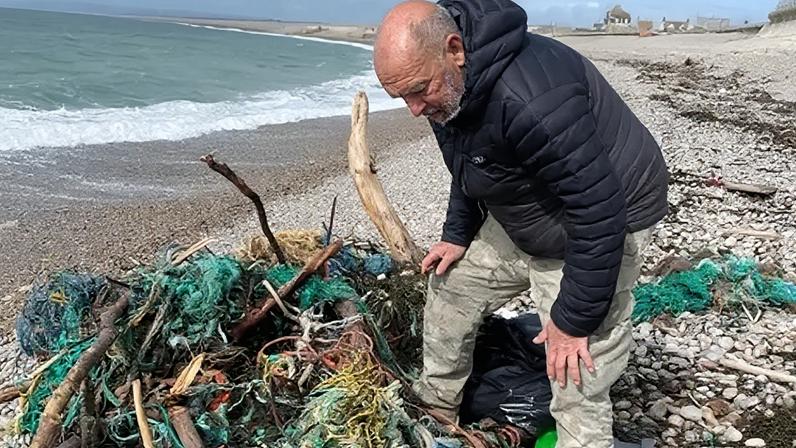 Voluntários limpam praia de resíduos de pesca após tempestade