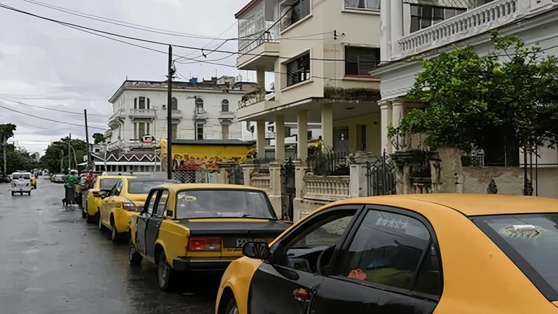 Taxistas em fila para abastecer em posto de gasolina em Havana, Cuba