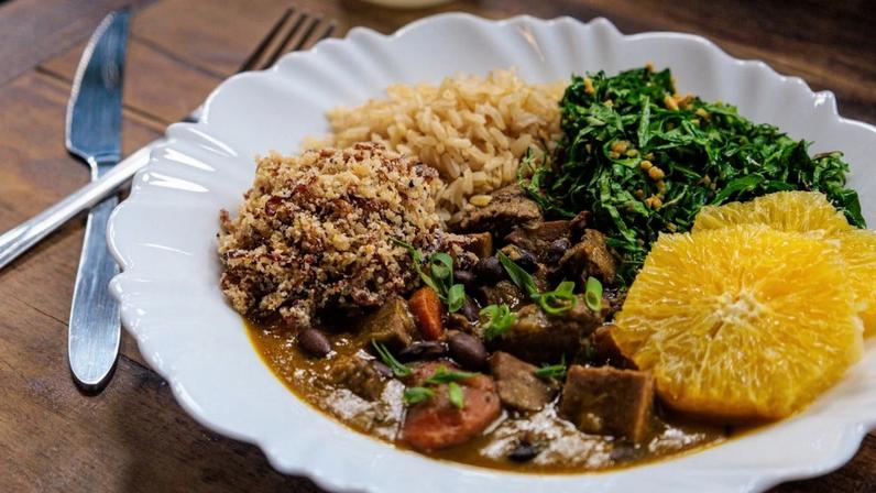 No cardápio do Comidaria Guerra tem feijoada vegana (feijão preto, legumes e proteínas vegetais) arroz, farofa de cebola tostada e couve com alho