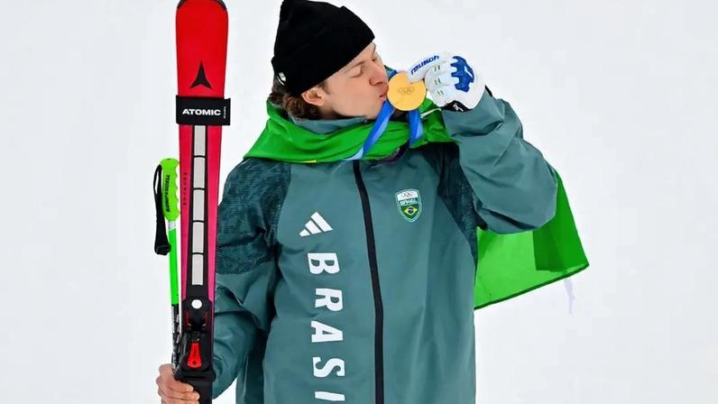 Lucas Pinheiro Braathen beija a medalha de ouro no pódio do slalom gigante masculino em 2026. (Foto: Fabrice Coffrini/AFP)