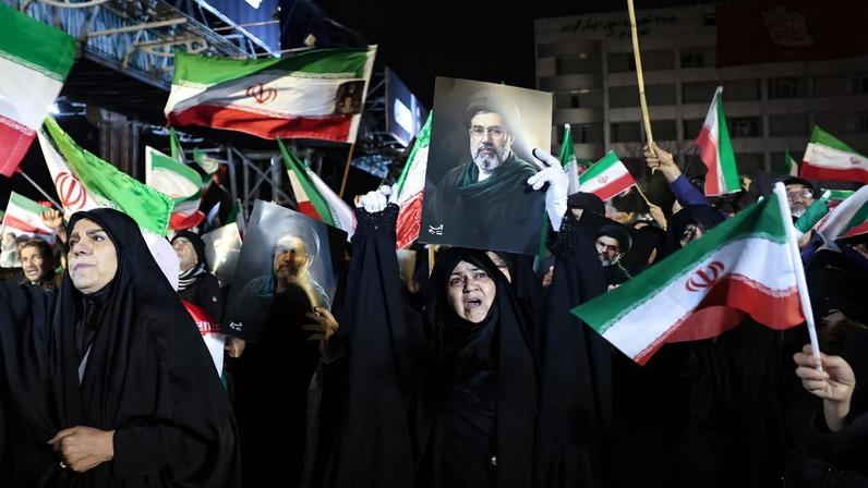 Pessoas agitam bandeiras nacionais e carregam retratos do líder supremo do Irã, Mojtaba Khamenei, enquanto marcham em apoio às forças armadas iranianas no centro de Teerã, em 25 de março de 2026
