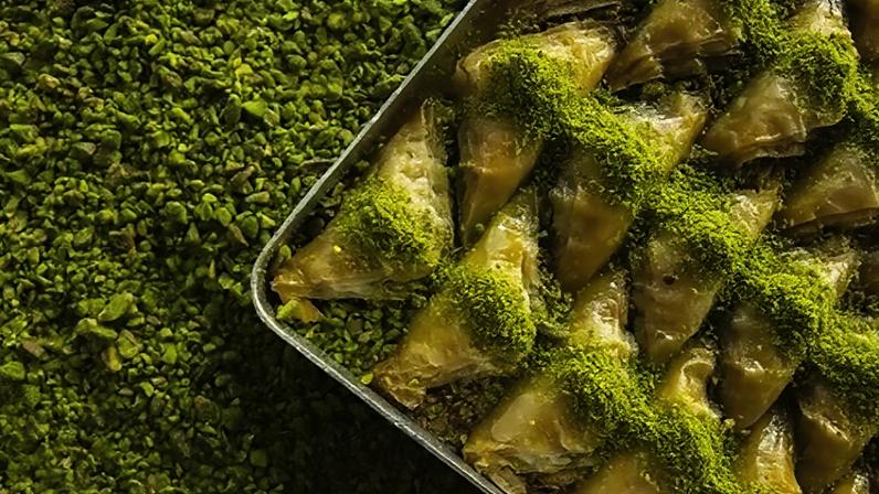 A tray of pistachio baklava over a bed of pistachios (Credit: Getty Images)