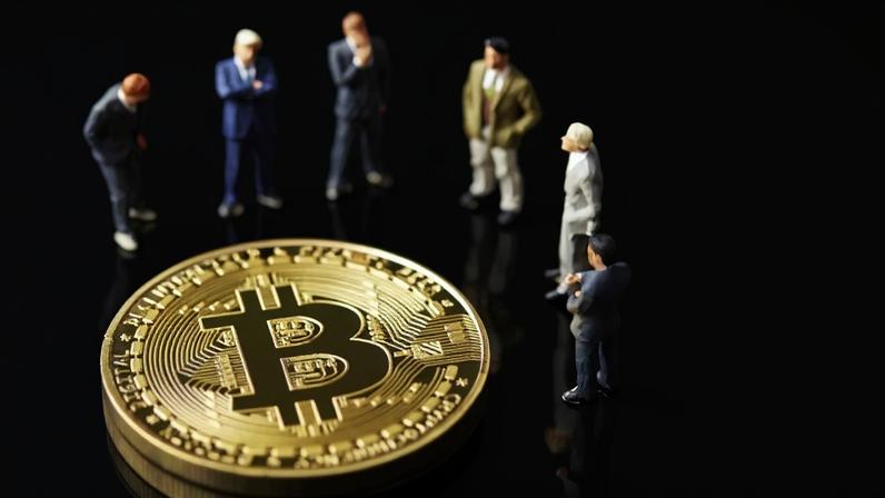 pessoas rodeiam bitcoin gigante