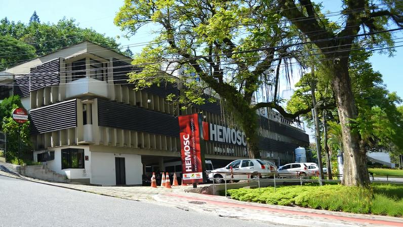 Imagem ilustrativa de campus de instituto federal: prédio moderno, gramado e céu aberto