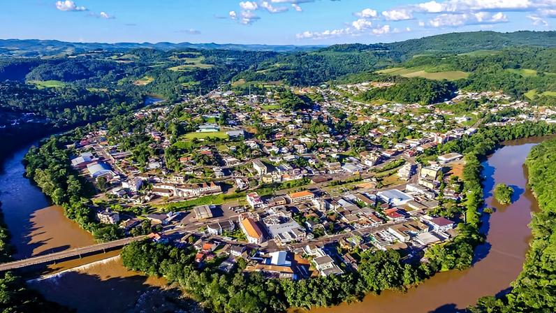 Vista aérea de Tangará SC, com áreas urbanas e vinhedos ao fundo.