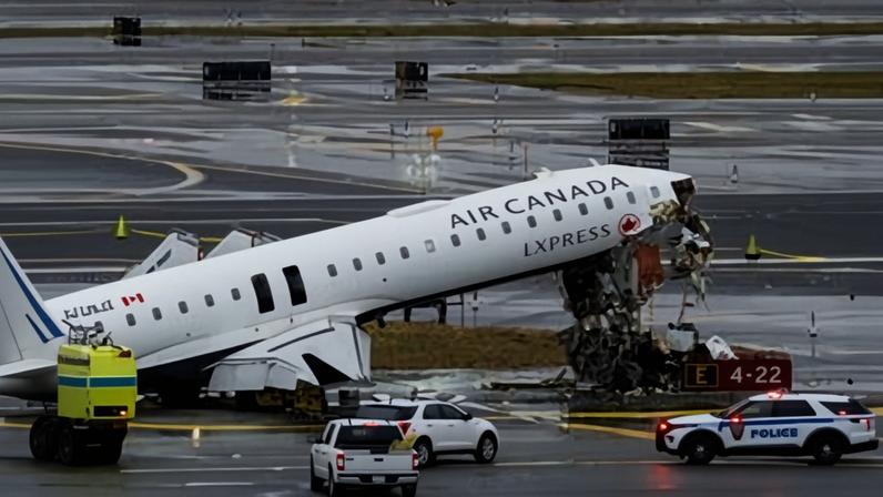 Photo of the collision scene on Runway 4 at LaGuardia Airport showing the damaged Air Canada jet. The aircraft’s cockpit section has been destroyed and its forward fuselage is angled sharply upward.