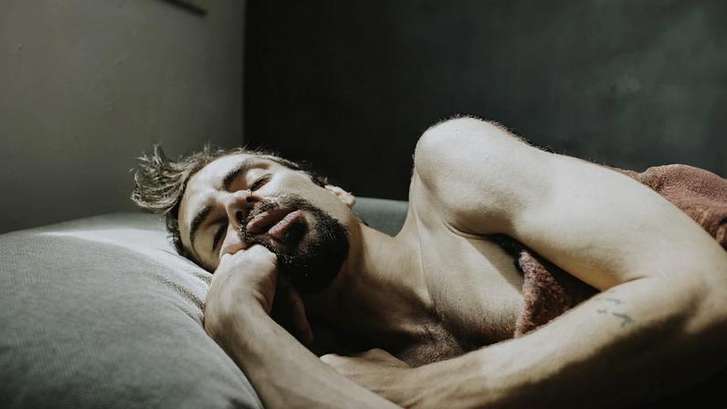Imagem mostra homem dormindo com a mão no rosto - Metrópoles