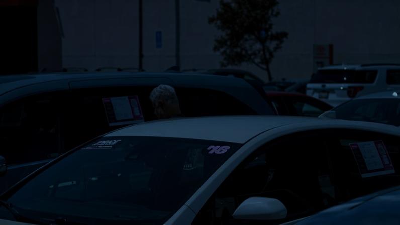 A customer looks at vehicles for sale at a car dealership in Hayward, California.