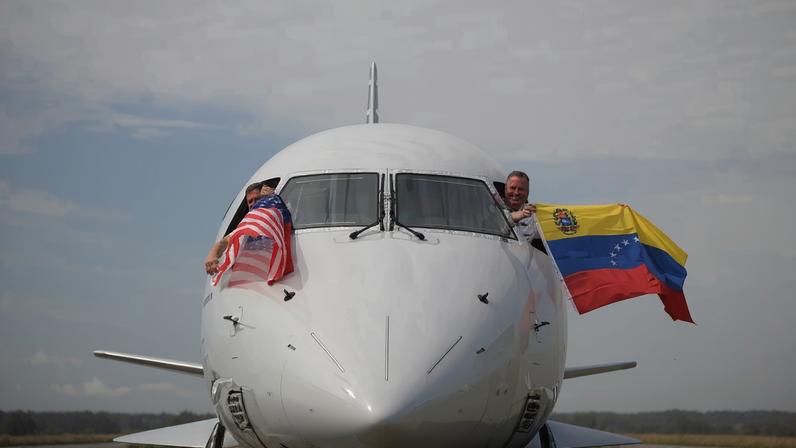 Pilotos do voo 3599 da American Airlines, partindo do Aeroporto Internacional de Miami com destino a Caracas, Venezuela, acenam com bandeiras venezuelanas e americanas antes da decolagem em um voo direto para a Venezuela, o primeiro entre os EUA e a Venezuela em sete anos, no Aeroporto Internacional de Miami, em Miami, Flórida, em 30 de abril de 2026.