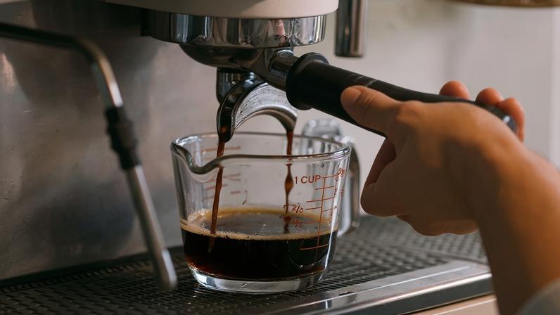 Fotografia de uma pessoa fazendo café.