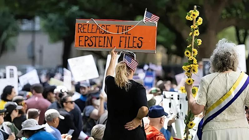 Getty Images A woman holds a sign at a protest saying "release the epstein files"