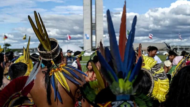 Fotografia da comunidade indígena marcha até o Congresso Nacional do Brasil durante o acampamento Tierra Livre.