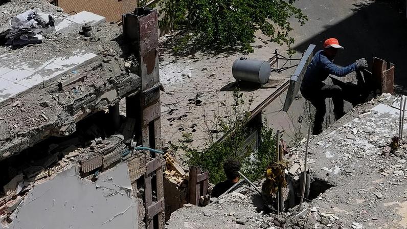 A worker climbs up a damaged residential building in southeastern Tehran, 14 April, 2026
