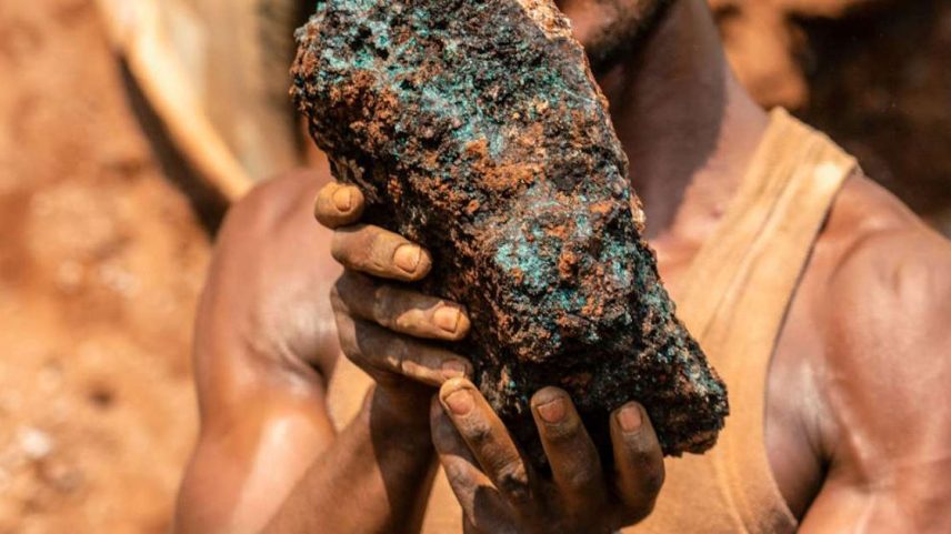 Um minerador artesanal segura uma pedra de cobalto em uma mina perto de Kolwezi, no Congo, em 2022: cerca de 20 mil pessoas trabalham ali em meio a materiais tóxicos, em operações que afetam a saúde e a segurança hídrica de toda população da região. Junior Kannah/AFP via Getty Images