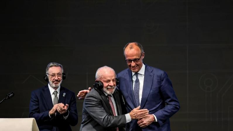 O chanceler alemão, Friedrich Merz (à dir.), abraça o presidente Lula durante visita à feira industrial de Hanôver, dedicada à engenharia mecânica e elétrica e às indústrias digitais. 20 de abril de 2026