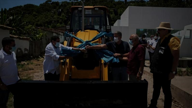 Homem entrega chave de máquina enfeitada com um laço em dia de muito sol