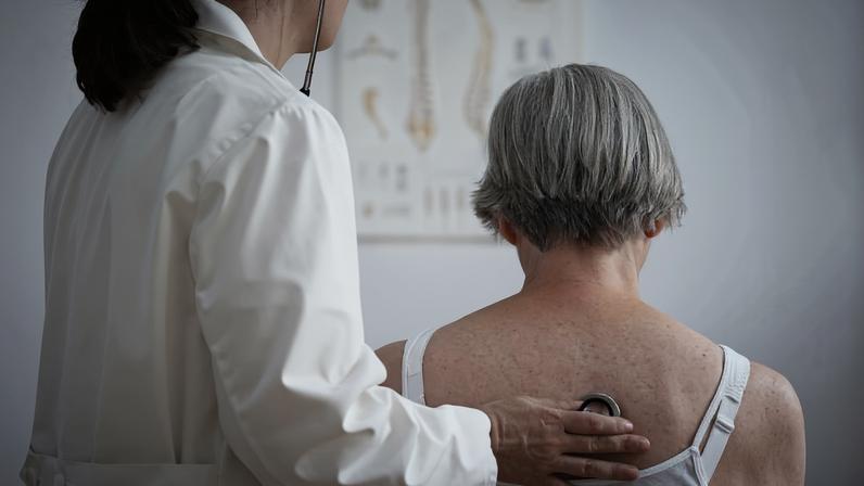 Médica ausculta pulmões de paciente