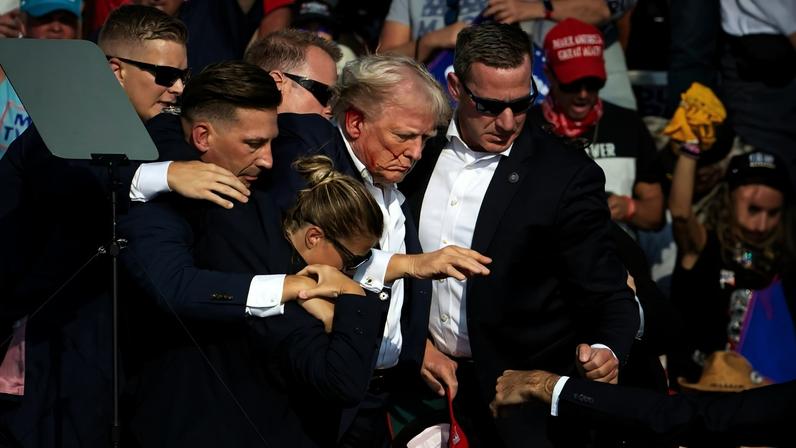 O presidente Donald Trump, quando ainda era candidato, é retirado do palco de um comício após tentativa de assassinato em Butler, na Pensilvânia, em julho de 2024