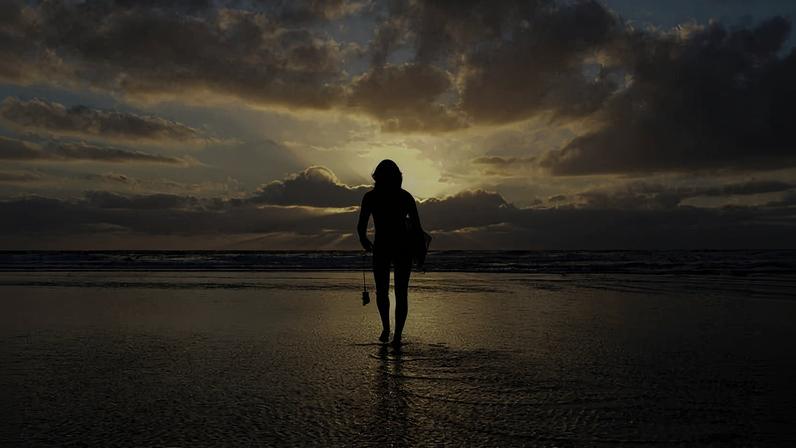 Mulher caminha em praia em Encinitas, na Califórnia (EUA)