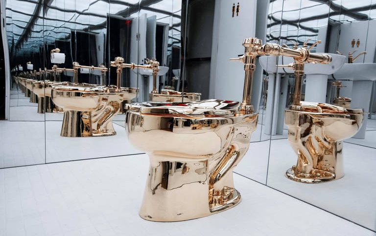 Obra "America", de Maurizio Cattelan, um vaso sanitário feito com 100 quilos de ouro maciço; vasos sanitários supostamente fracos são incômodo para o presidente dos EUA