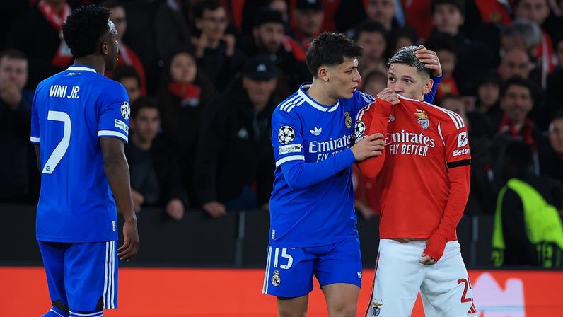 Gianlucca Prestianni, do Benfica, cobre a boca em discussão com o brasileiro Vinicius Junior, do Real Madrid, em partida da Champions League