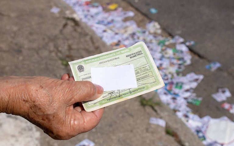Eleitora exibe título de eleitor e comprovante de votação