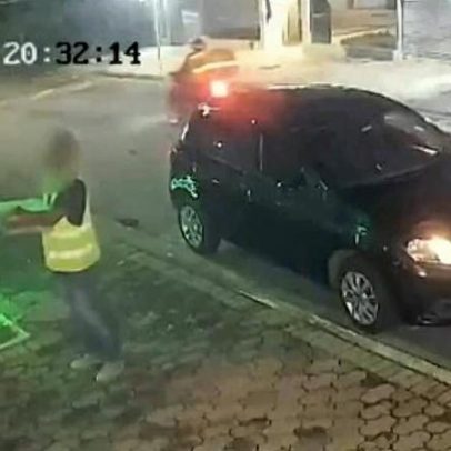 Entregador arremessa espumantes sobre portão; bebidas se quebram no chão