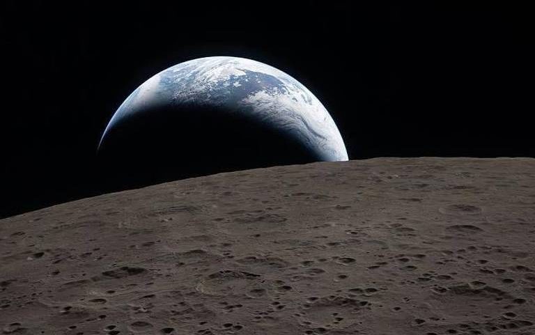 Terra parcialmente visível surgindo atrás da superfície acinzentada e craterada da Lua, com o espaço negro ao fundo.