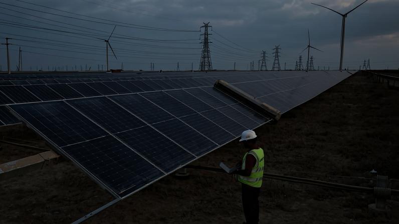 Funcionário checando funcionamento de equipamentos em parque de energia solar do grupo Adani, em Khavda, na Índia