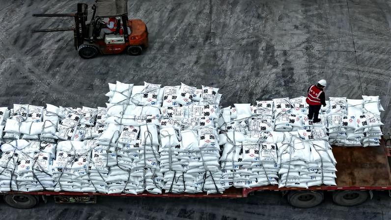 Trabalhadores transportam fertilizantes na província de Guizhou, na China