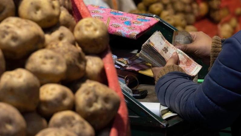 Uma vendedora conta notas em seu ponto de vendas no Mercado Santa Anita, em Lima