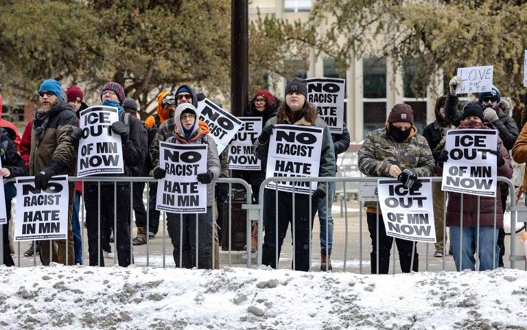 Manifestantes contrários ao ICE (Serviço de Imigração e Controle de Alfândega dos EUA) ficam próximos em Minneapolis, Minnesota. Os manifestantes se reuniram após a continuidade de ações federais de fiscalização migratória apelidadas de Operation Metro Surge