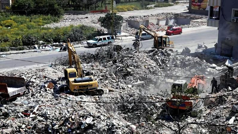 Equipes de resgate trabalham na remoção de escombros de um prédio atingido em um ataque israelense no vilarejo de Hanaouay, no sul do Líbano