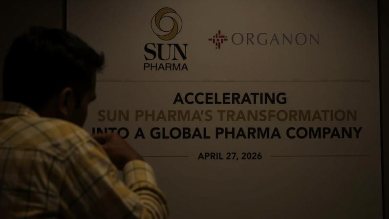 Um homem passa por uma tela durante uma coletiva de imprensa que anunciava a aquisição da empresa farmacêutica americana Organon pela Sun Pharmaceutical Industries Ltd., em Mumbai, Índia, em 27 de abril de 2026