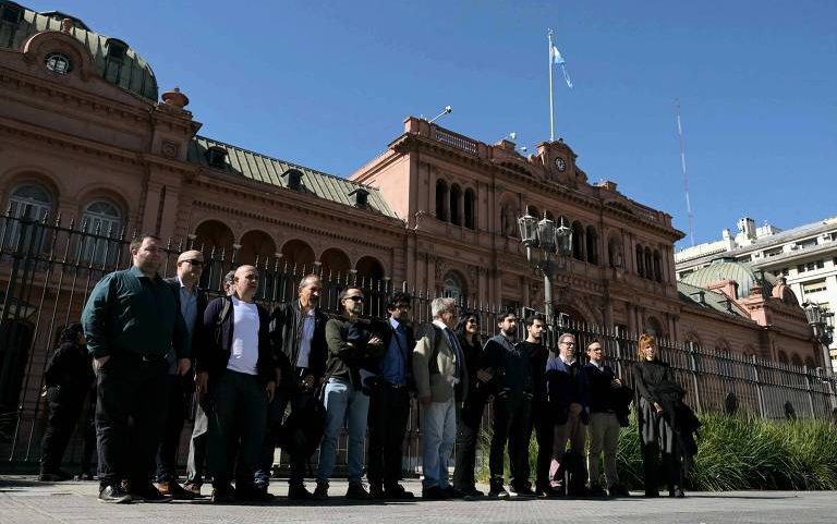 Jornalistas credenciados posam para fotos em frente à Casa Rosada, em Buenos Aires, após o governo proibir o acesso dos profissionais ao prédio
