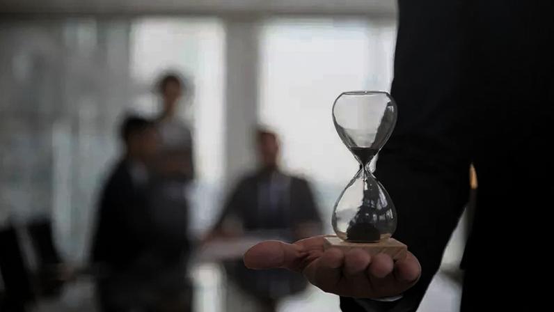 Businessman holding an hour glass, signifies the importance of being on time