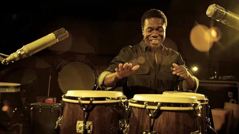 Paulinho da Costa tocando um instrumento durante gravações do documentário