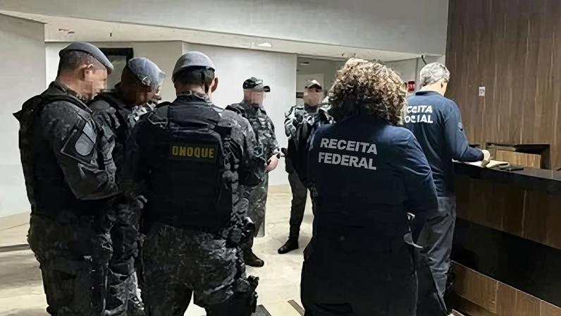 Policiais fazem segurança durante operação contra lavagem de dinheiro em São Paulo. Grupo investigado teria ligação com o PCC, segundo promotores. - (crédito: AFP)