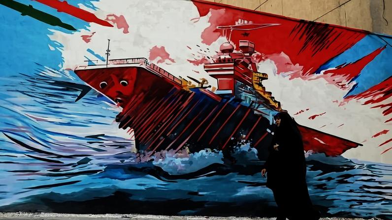 Mulher iraniana caminha diante de mural com desenho anti-Estados Unidos, no centro da capital Teerã - (crédito: Atta Kenare/AFP)