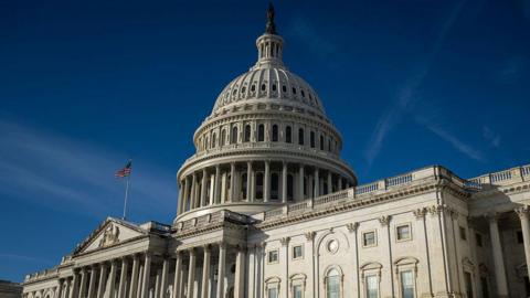Getty Images The exterior of the US Capital Building showing a US flag waving in front of its rotunda in Washington DC.