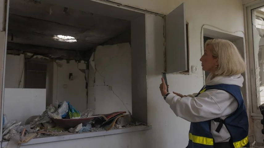 Janna Yehuda of Israel’s Property Tax Compensation Fund examines missile damage in Kiryat Ata near Haifa, Israel.