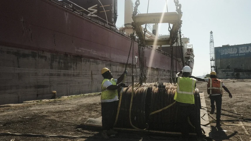Workers unload from a freight ship in the dockyard at the Port of Detroit.