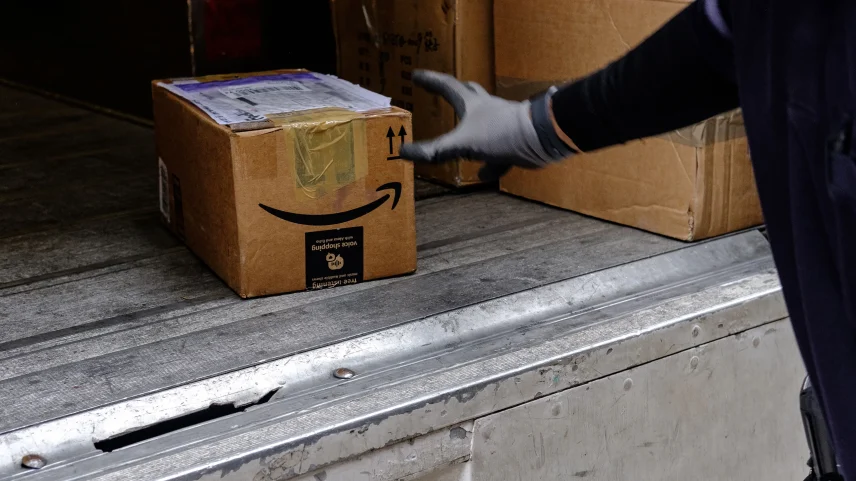 A driver unloads an Amazon.com Inc. package from a delivery truck in New York.