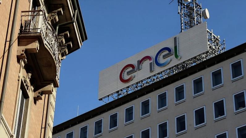 Prédio da Enel com logo colorido e antena no telhado, com edifício clássico com sacada à esquerda.