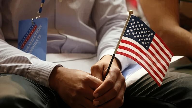 Um novo cidadão segura uma bandeira dos EUA em cerimônia de naturalização do Serviço de Cidadania e Imigração dos EUA na Biblioteca Pública de Nova York03/07/2018REUTERS/Shannon Stapleton