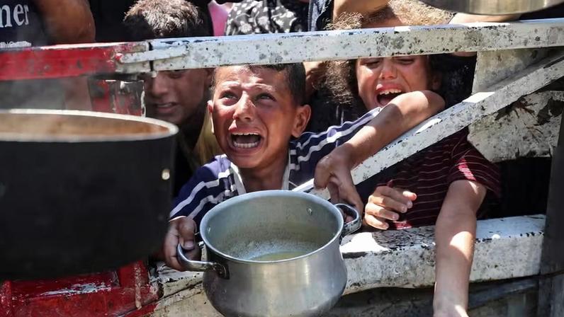 Palestinians wait to receive food from a charity kitchen, in Gaza City Food Fome — Foto: Mahmoud Issa/REUTERS