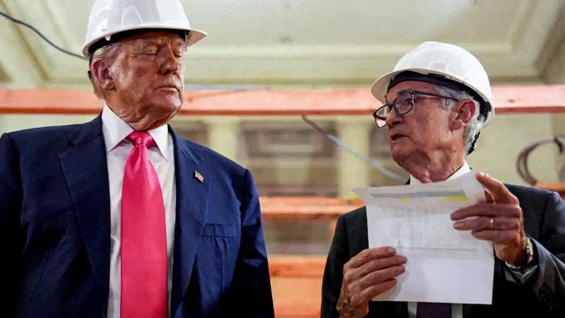 O presidente dos EUA, Donald Trump, observa o presidente do Federal Reserve, Jerome Powell, segurando um documento durante uma visita ao prédio do Federal Reserve - 24/07/2025 (Foto: REUTERS/Kent Nishimura)